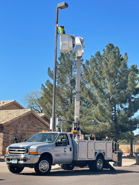 Man painting pole with proper equipment from truck